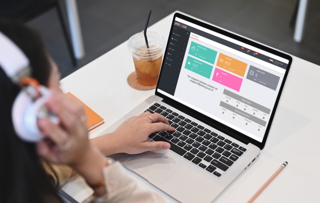 PickMyCar operations portal on laptop showing summary dashboard and job tracking